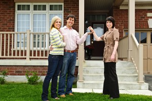 Happy couple getting keys to new house from real estate agent